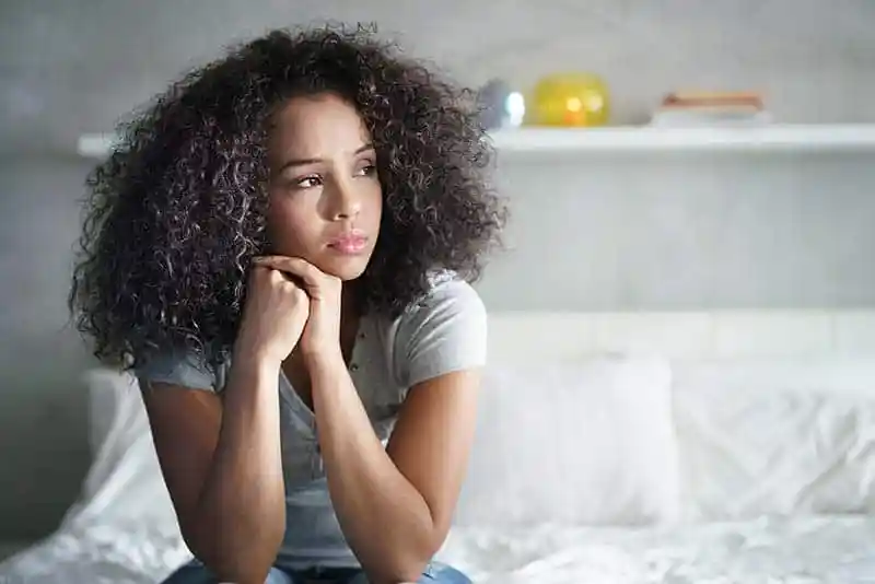 A black woman is thinking about how to solve problems encountered during international travel when it's solo trip.