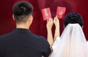 A Chinese and a Filipino stand with their backs to the camera, holding a marriage certificate, symbolizing marry in China.