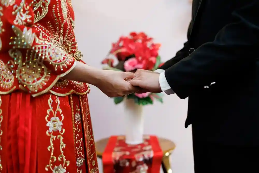 A newlywed couple, dressed in wedding attire, hold hands, symbolizing a blissful marriage in China.