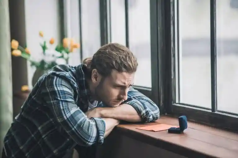 a man whose undecided on his decision staring at the ring which symbolize marriage