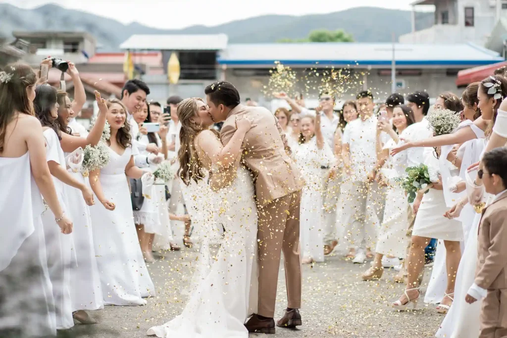 a happy couple who just got married ,kissing each other passionately with their witnesses
