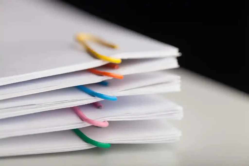 Several visa documents clipped together with paperclips
