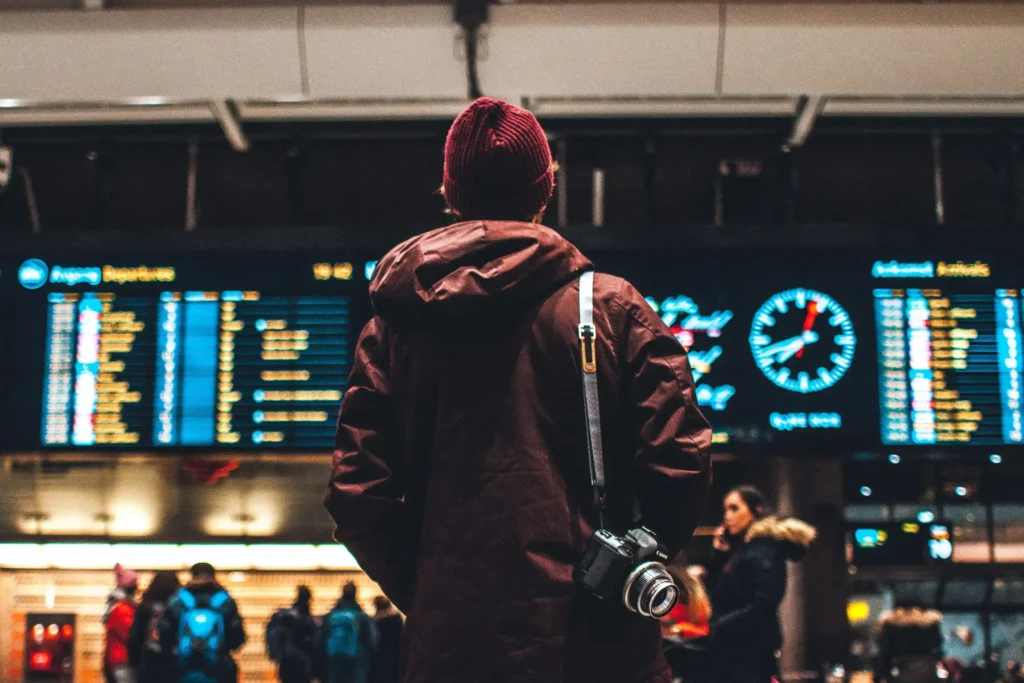 A man stood in front of the immigration office in the airport, holding a travel guide, preparing for China travel.