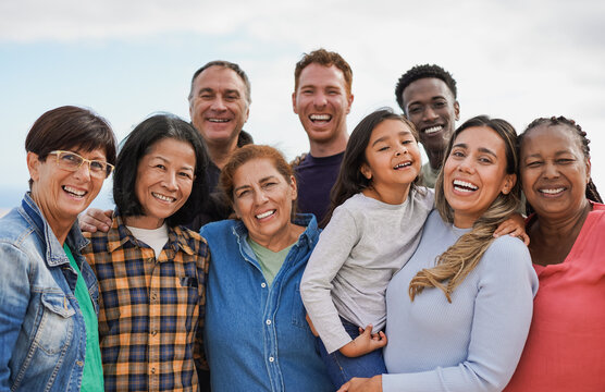 A joyful group photo of people of all skin colors and nationalities.